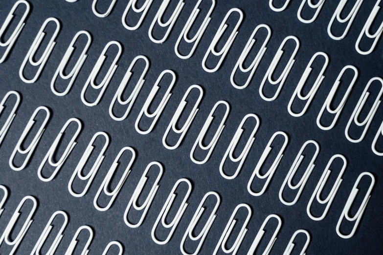 a close up of a bunch of paper clips, an album cover, trending on pexels, op art, white mechanical details, on a dark background, repeating patterns, blue archive