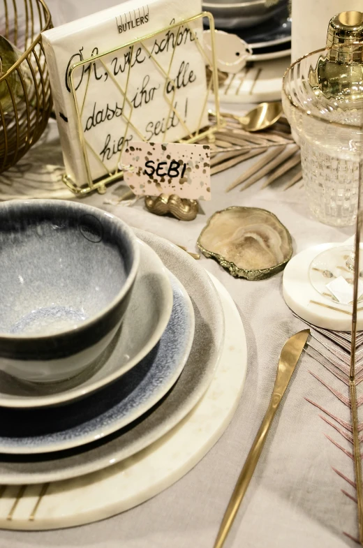 a white table topped with plates and silverware, by Else Alfelt, grey and blue theme, close-up photo, festive, hamar