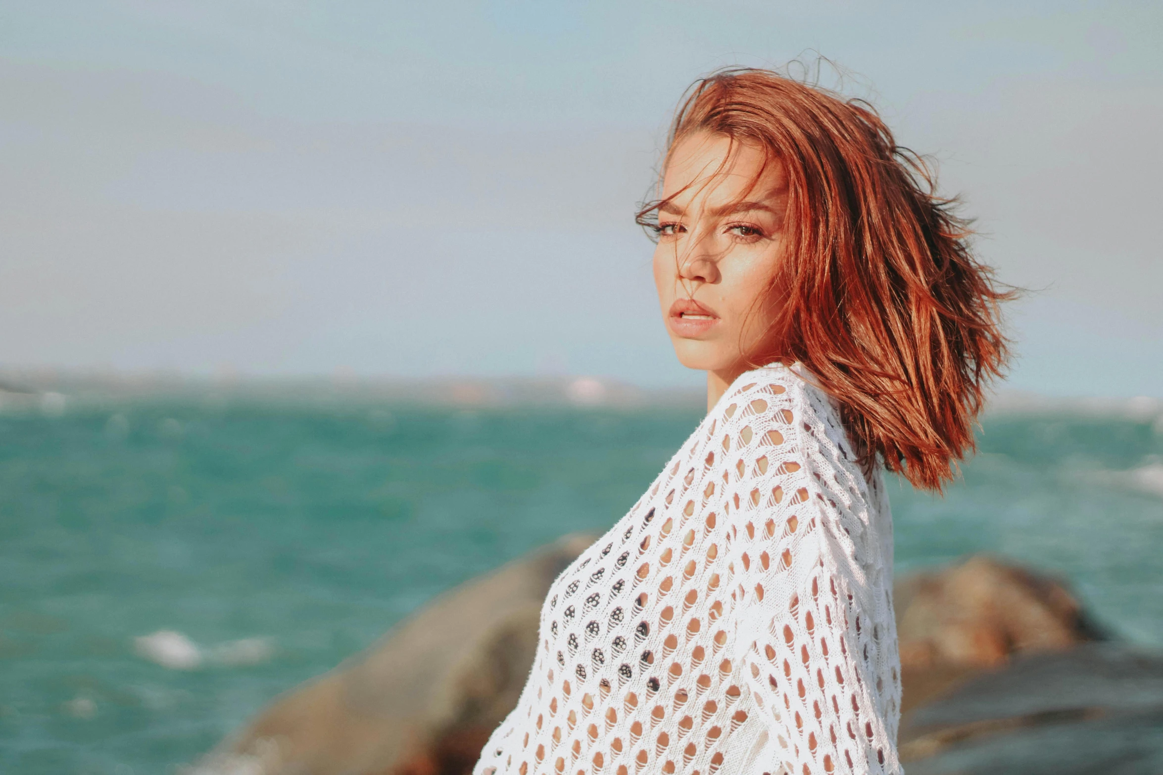 a woman standing in front of a body of water, chloe bennet, ginger hair with freckles, profile image, sofya emelenko