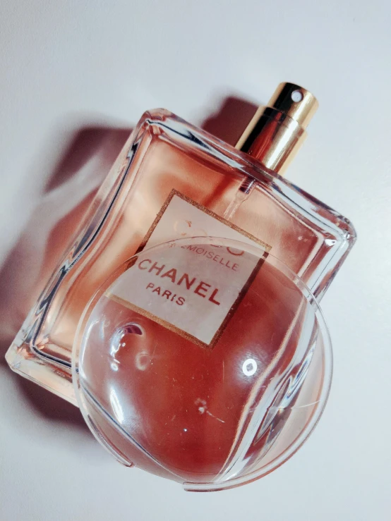 a bottle of perfume sitting on top of a table, by Andrée Ruellan, 🎀 🧟 🍓 🧚, high detailed), faded pink, chanel