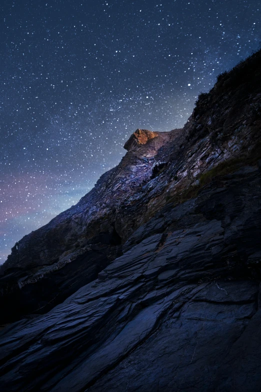 a mountain with a star filled sky in the background, inspired by Michal Karcz, unsplash contest winner, rocky cliffs, new zealand, chiseled jawline, 8k detail post processing