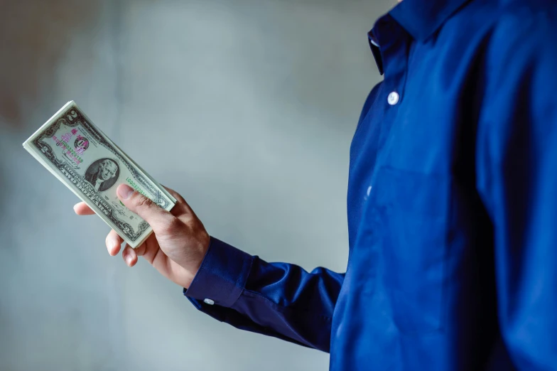 a man in a blue shirt holding a stack of money, pexels contest winner, renaissance, avatar image, getty images, tall thin, mystery