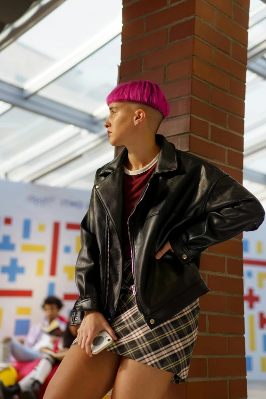 a woman wearing a plaid skirt and a leather jacket, an album cover, by Cosmo Alexander, in school hallway, genderless, wearing a purple cap, shaved sides