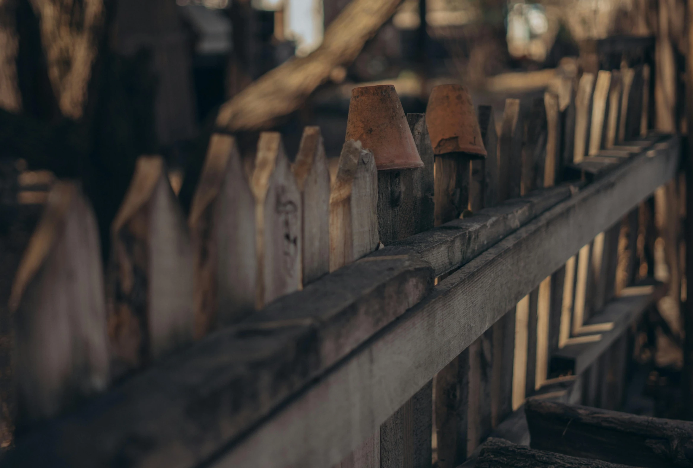 a close up of a wooden fence with a building in the background, a tilt shift photo, pexels contest winner, visual art, background image, old furnitures, in a row
