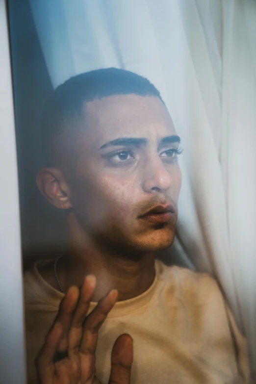 a man that is looking out of a window, an album cover, by Ahmed Yacoubi, trending on pexels, hyperrealism, lgbtq, shaven face, still from a music video, worried