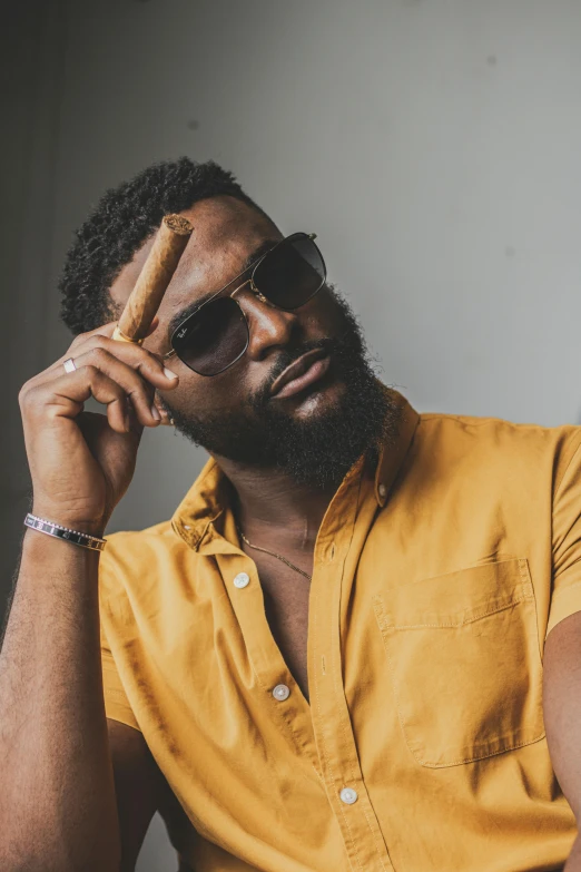 a man in a yellow shirt smoking a cigar, an album cover, inspired by Michael Ray Charles, unsplash, thick black beard, mkbhd, pose model, icon