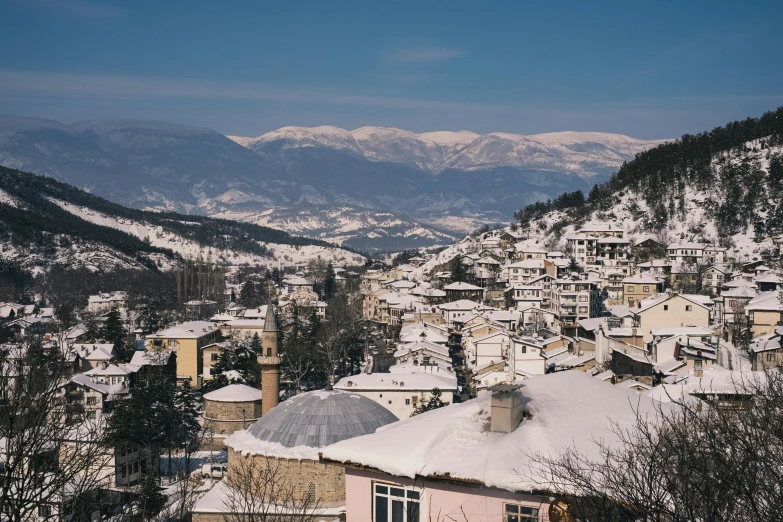 a town covered in snow with mountains in the background, by Emma Andijewska, mount olympus, wide high angle view, high quality image”, conde nast traveler photo