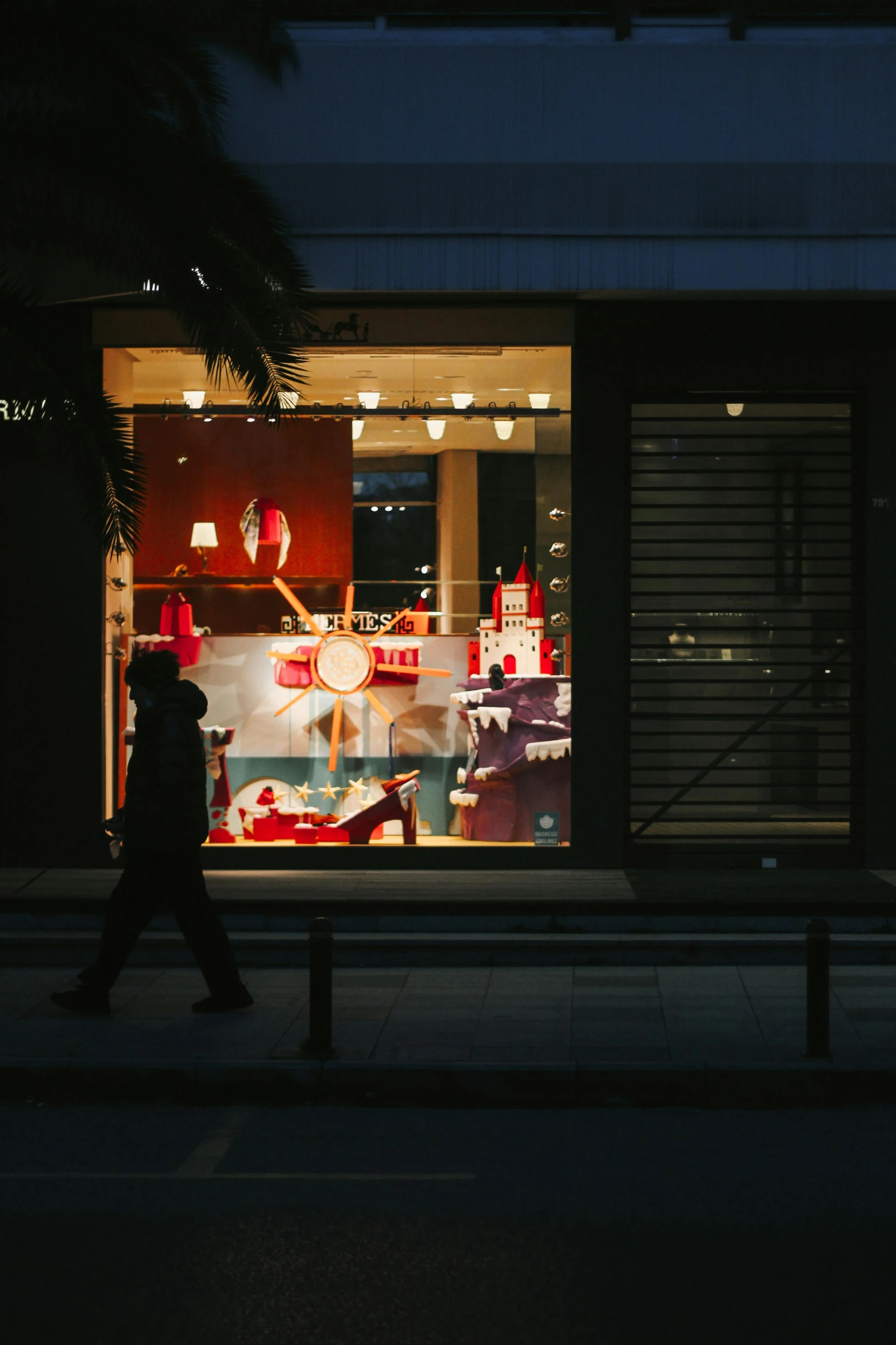 a person walking in front of a store at night, pexels contest winner, red and white lighting, van cleef & arpels, nice afternoon lighting, holiday season