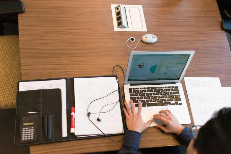 a person sitting at a table working on a laptop, devices and instruments, ignant, uploaded, bottom angle