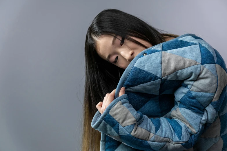 a woman covering her face with a blanket, inspired by Kim Tschang Yeul, trending on unsplash, hyperrealism, denim jacket, quilt, asian woman made from origami, half turned around