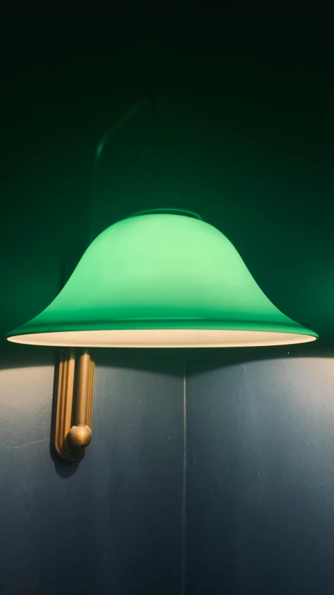 a close up of a light on a wall, inspired by Joseph Wright of Derby, unsplash, green hat, cyan and gold scheme, instagram picture, indoor lighting