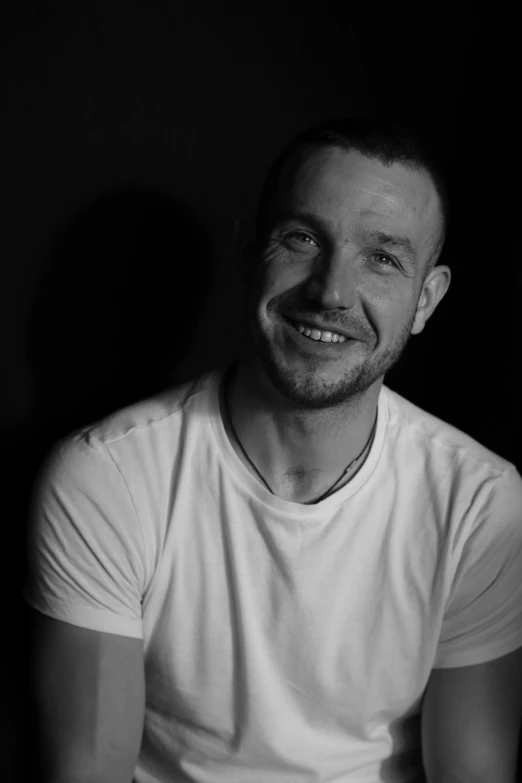 a black and white photo of a man smiling, inspired by James Morrison, liam, artem, smiling into the camera, dark and white