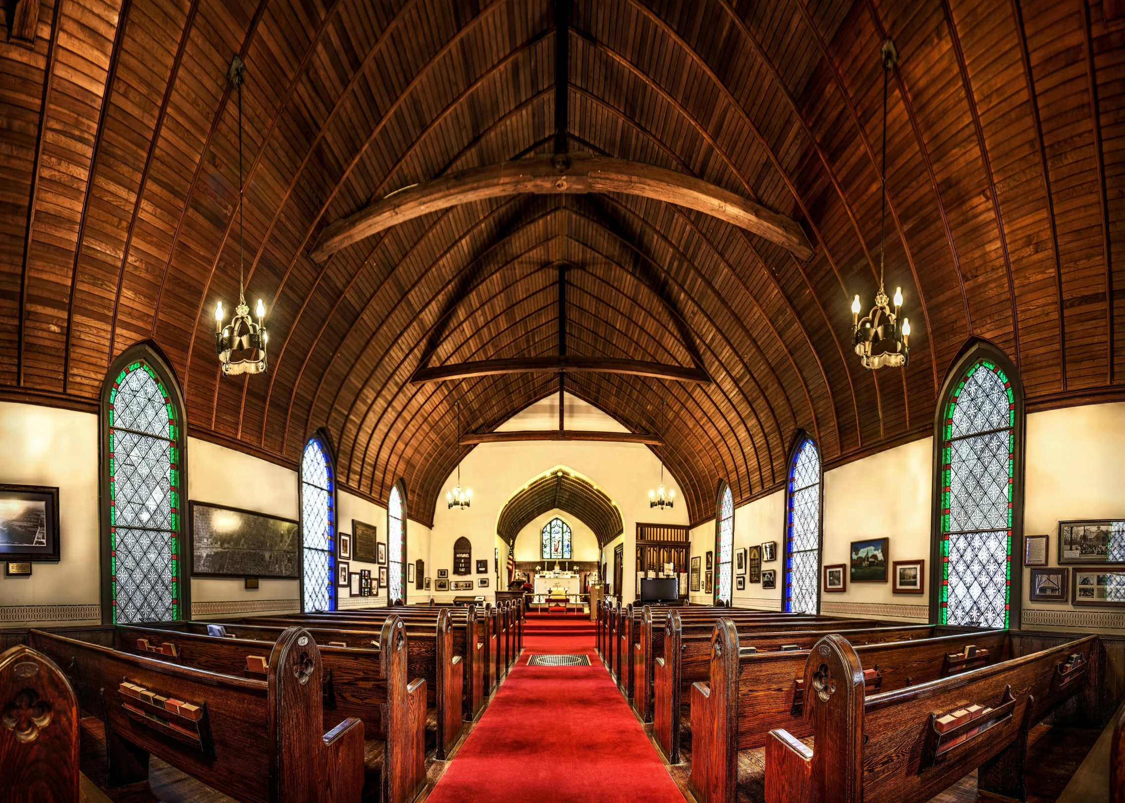 a church filled with wooden pews and a red carpet, a portrait, by Jessie Algie, pexels, arched ceiling, a quaint, panoramic, southern gothic scene