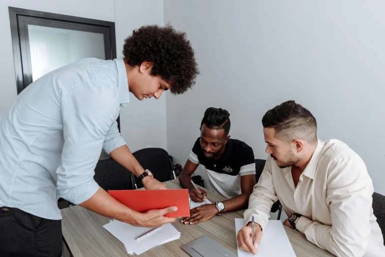 a group of men sitting around a wooden table, on a desk, whiteboards, lachlan bailey, black man with afro hair