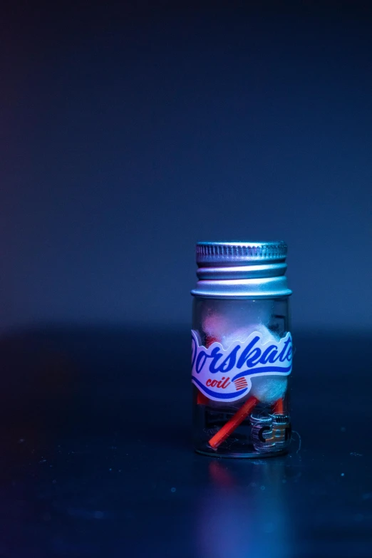 a can of soda sitting on top of a table, an album cover, by James Warhola, unsplash, photorealism, blue and red lights, glass jar, metaballs, scale model photography