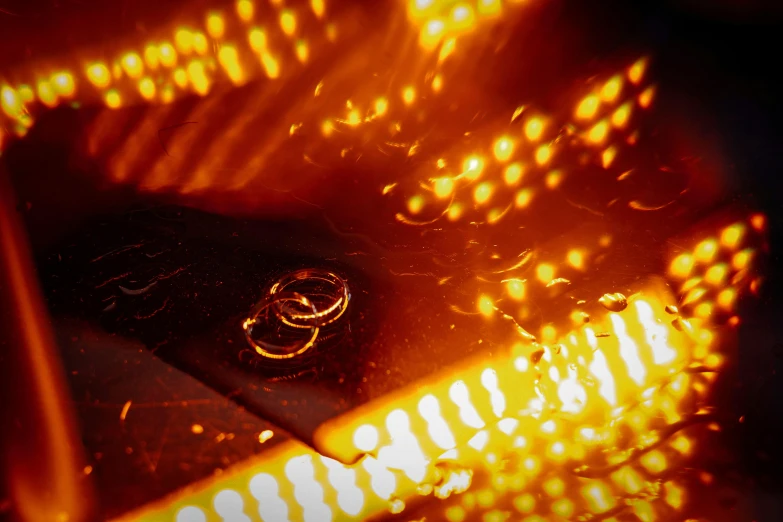 a couple of wedding rings sitting on top of a table, by Bernard Meninsky, holography, with orange street lights, the fire is made of binary code, high angle close up shot, shot on kodak vision 200t