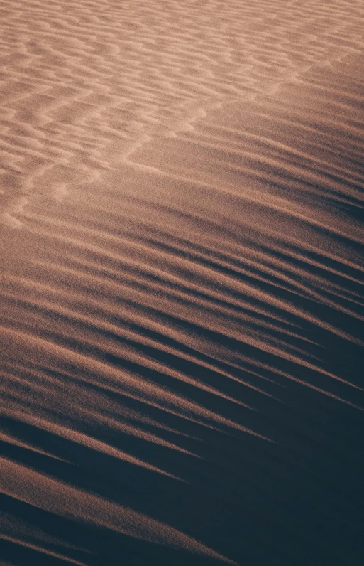 a person riding a snowboard on top of a snow covered slope, trending on unsplash, lyrical abstraction, texture of sand, purple sand, ripples, mojave desert