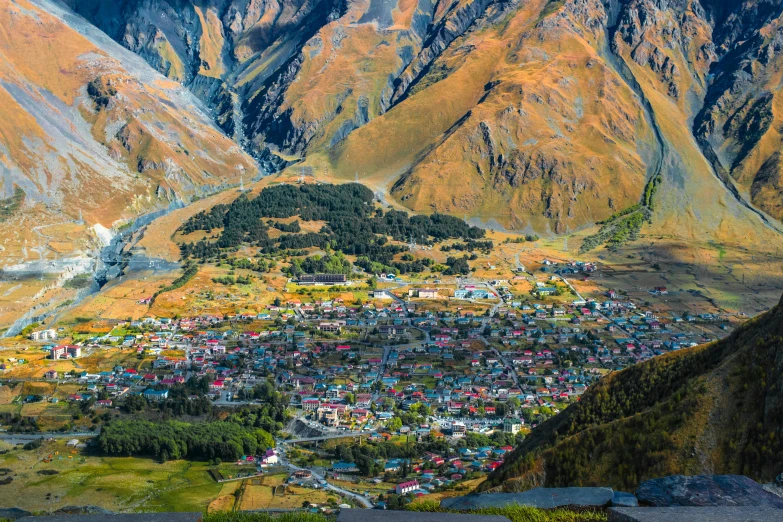 a view of a small town in the mountains, by Muggur, pexels contest winner, art nouveau, new zealand, georgic, city of pristine colors, in a mountain valley