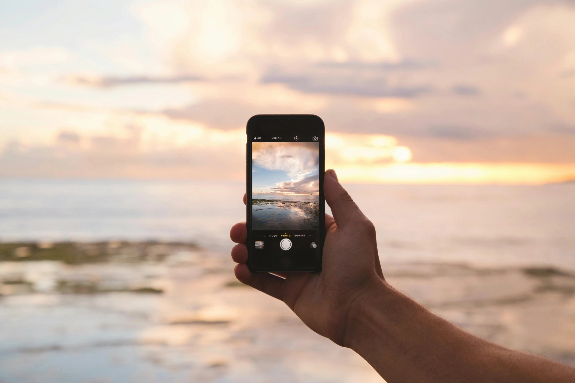 a person taking a picture of the ocean at sunset, iphone in hand, iconic design, ecommerce photograph, large screen