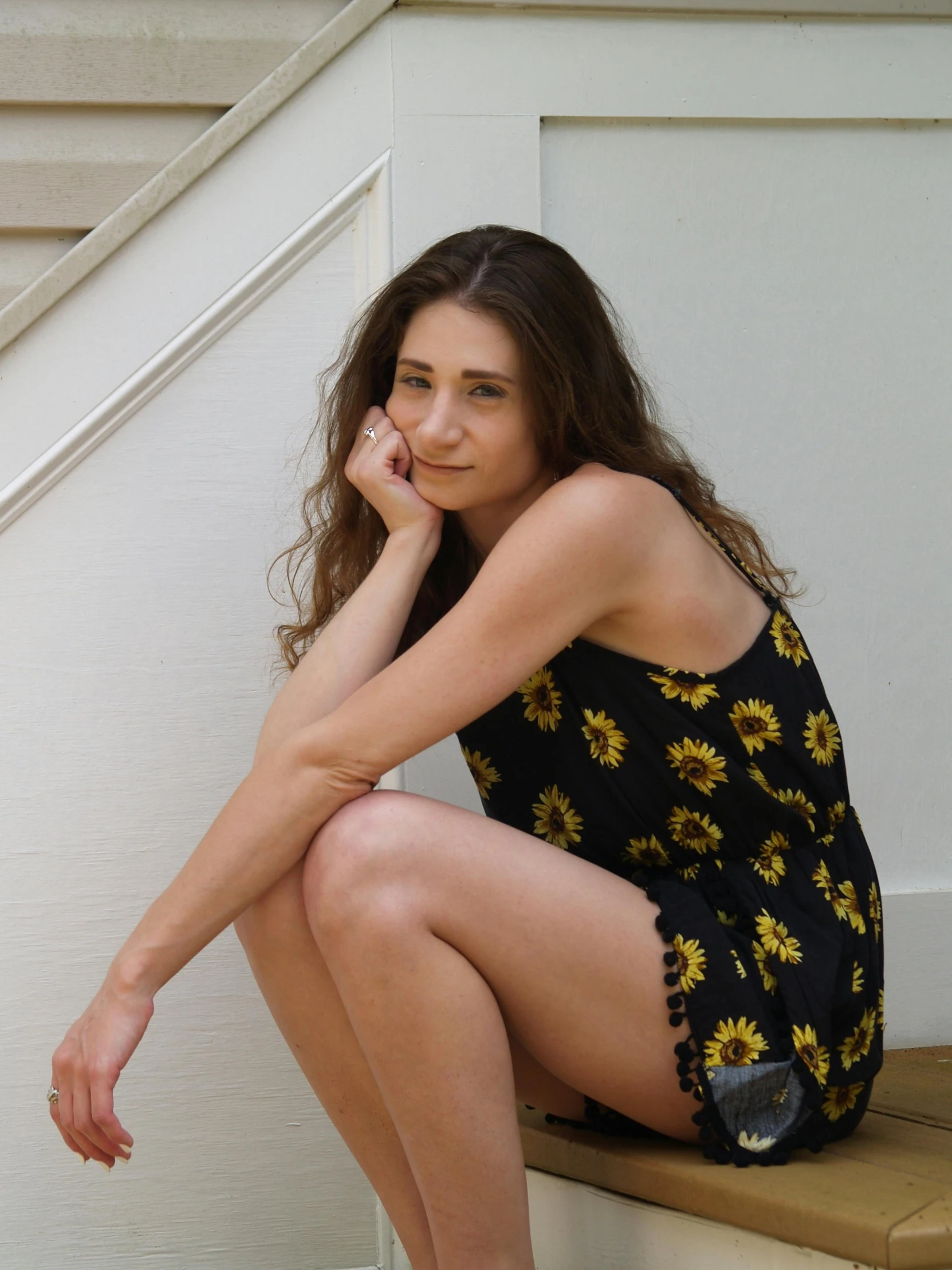 a woman sitting on the steps of a house, an album cover, by Lucette Barker, pexels contest winner, sunflowers, tight black tank top and shorts, thoughtful pose, patterned clothing