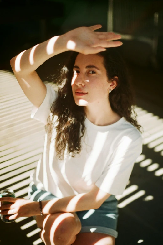 a woman sitting on a bench with her hands on her head, pexels contest winner, light and space, rebecca sugar, wearing a white shirt, sun lighting from above, asher duran