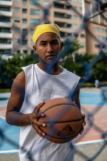 a man holding a basketball on top of a basketball court, thawan duchanee, androgynous male, wearing a white bathing cap, wearing yellow croptop