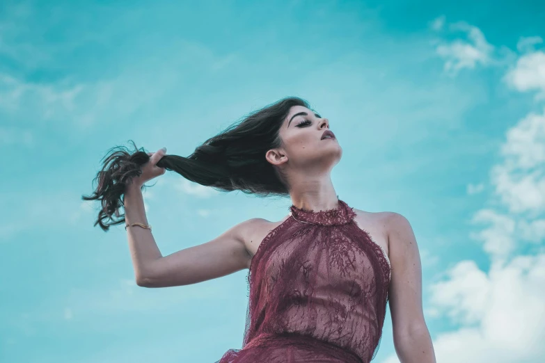 a woman with her hair blowing in the wind, by Niko Henrichon, pexels contest winner, renaissance, teal sky, wearing red tank top, dancing elegantly over you, charli bowater