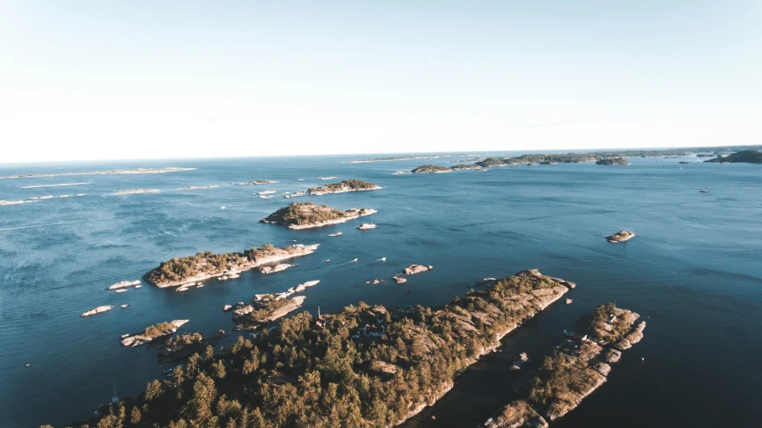 a group of boats floating on top of a body of water, by Jesper Knudsen, pexels contest winner, hurufiyya, scattered islands, alvar aalto, view from the sky, thumbnail