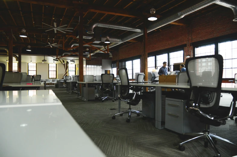 a group of people sitting at desks in an office, by Carey Morris, unsplash, interior of a loft, pristine and clean, ignant, engineering bay