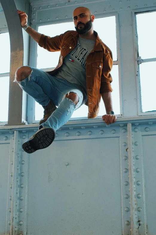 a man flying through the air while riding a skateboard, trending on pexels, an aviator jacket and jorts, standing near a window, caramel. rugged, high above the ground