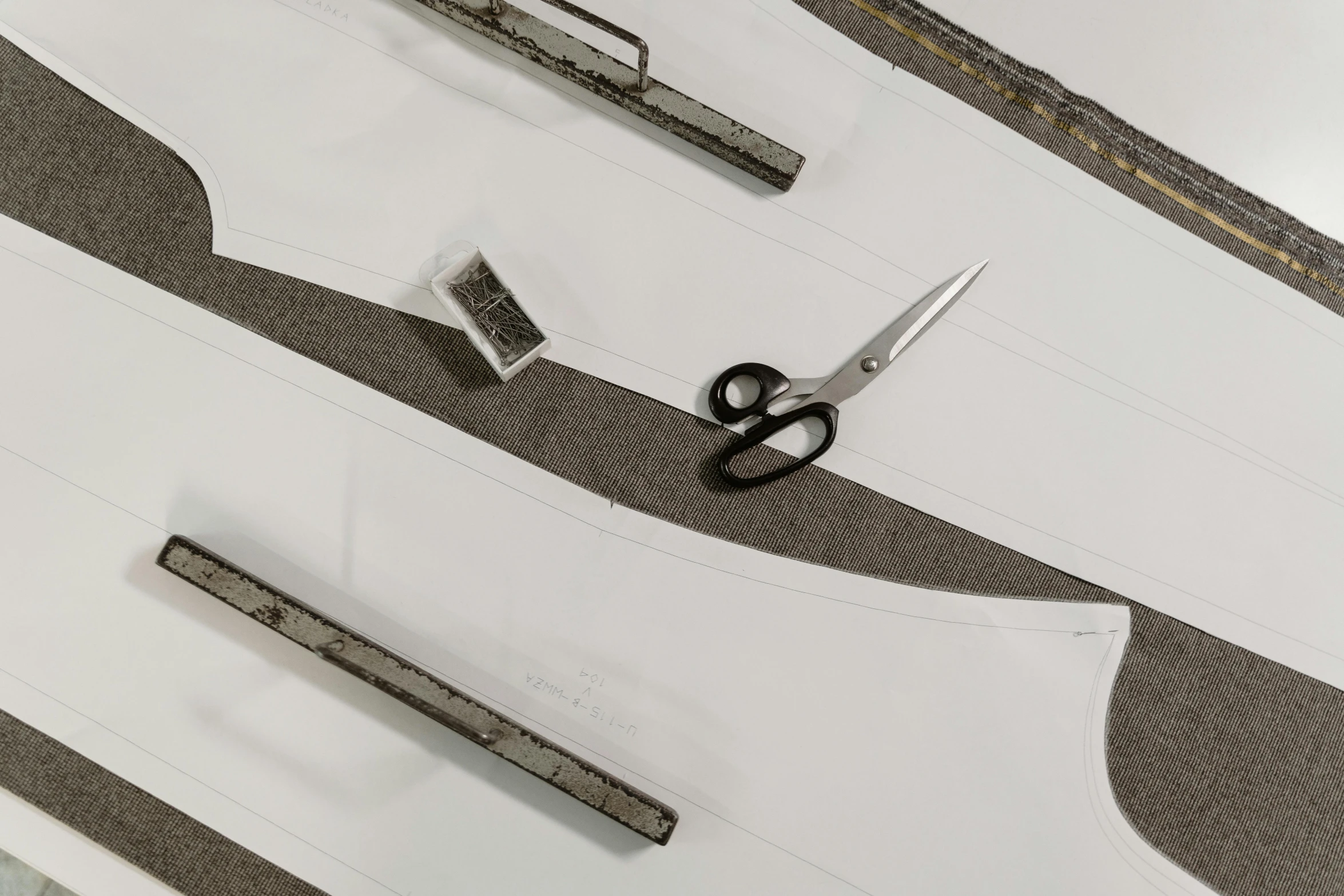 a pair of scissors sitting on top of a piece of paper, a charcoal drawing, inspired by László Moholy-Nagy, metal garments, technical detail, assembly instructions, made in tones of white and grey