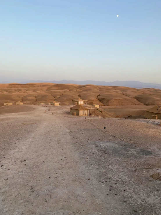 a dirt road in the middle of a desert, les nabis, makeshift houses, at dusk!, sand - colored walls, looking down on the view