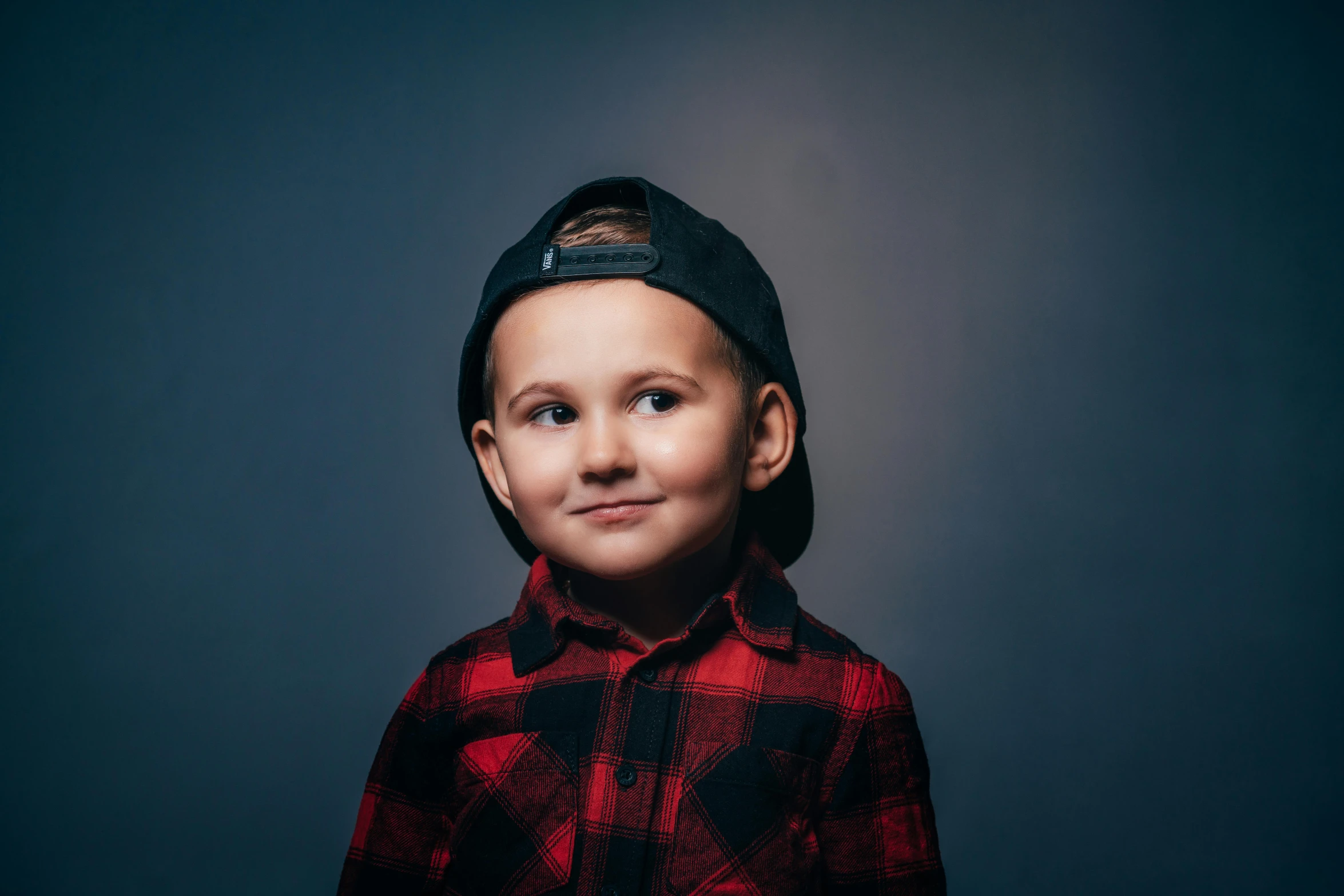 a young boy wearing a hat and plaid shirt, a character portrait, by Adam Marczyński, pexels contest winner, dark. studio lighting, 15081959 21121991 01012000 4k, portrait of a small, wearing a red backwards cap