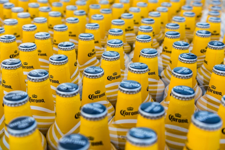 a bunch of beer bottles sitting on top of a table, corona, colors: yellow, fan favorite, felipe pantone