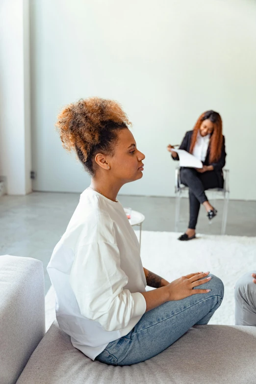 two women sitting on a couch talking to each other, trending on pexels, process art, sitting in an empty white room, black young woman, hypnosis, person in foreground