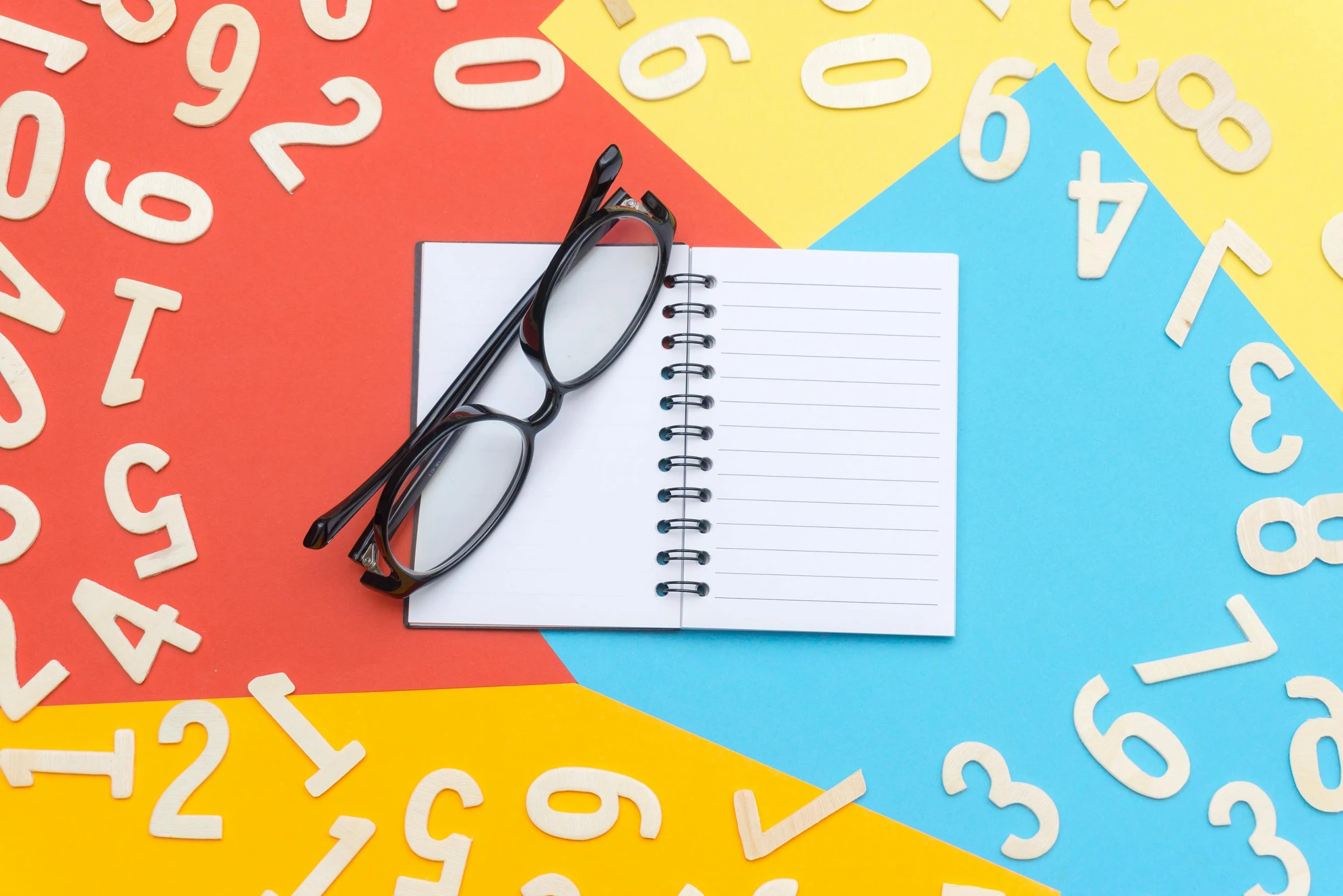 a notebook and glasses on a colorful background with numbers, by Julia Pishtar, pexels, letterism, square rimmed glasses, casual game, background image