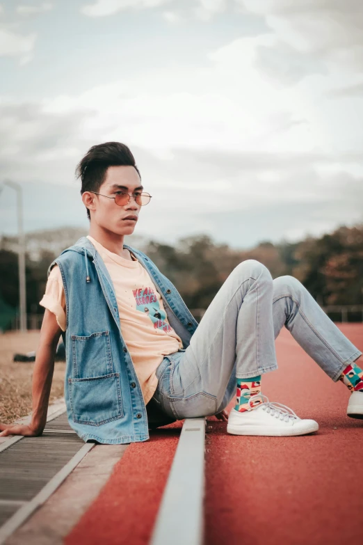 a man sitting on a track with his legs crossed, by Cosmo Alexander, trending on pexels, aestheticism, attractive androgynous humanoid, asian man, jeans and t shirt, pastell colours