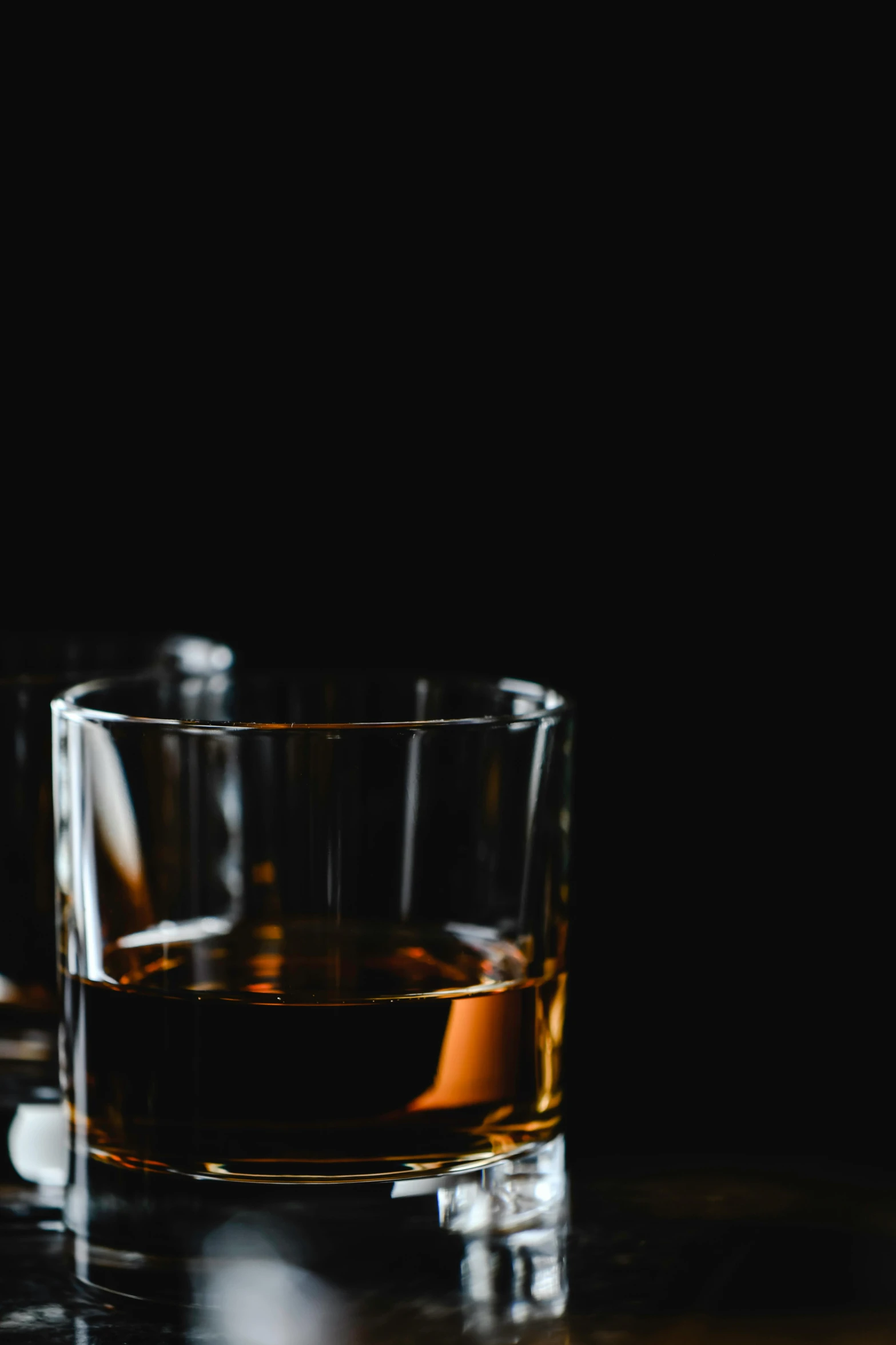 a glass of whiskey sitting on top of a table, inspired by William Grant Stevenson, unsplash, square, black, thumbnail, premium