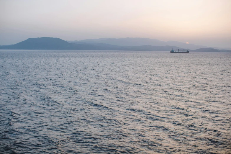 a large body of water with a boat in the distance, pexels contest winner, demna gvasalia, early evening, greece, container ship