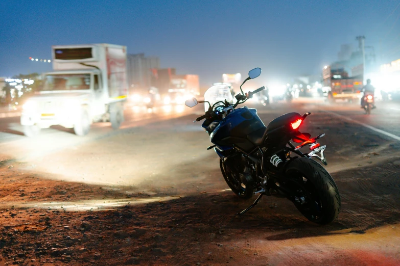 a motorcycle is parked on the side of the road, pexels contest winner, busy night, pulsar, on the desert, profile image