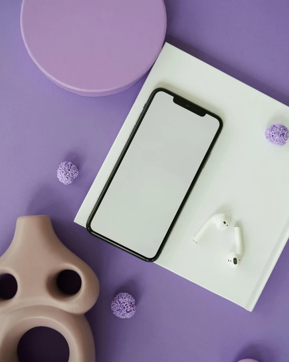 a cell phone sitting on top of a purple surface, a picture, airpods, looking towards camera, ((purple)), white paper