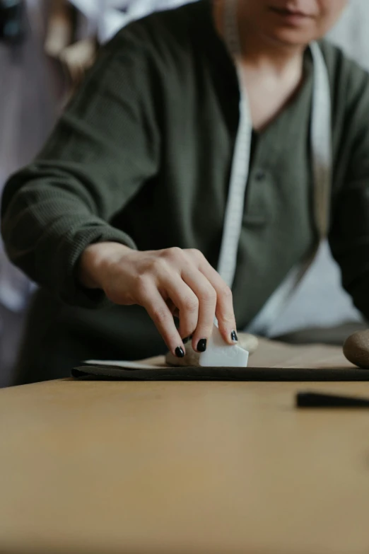 a woman sitting at a table using a computer mouse, trending on unsplash, arbeitsrat für kunst, holding a wood piece, stone carving, video still, matte surface