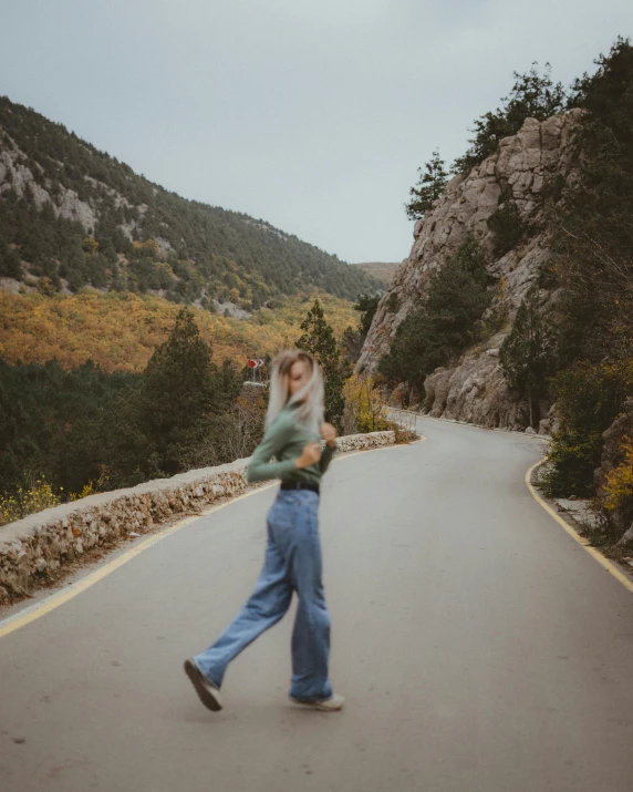 a woman walking down the middle of a road, a polaroid photo, pexels contest winner, girl dancing on cliff, wearing cargo pants, 🍂 cute, in spain