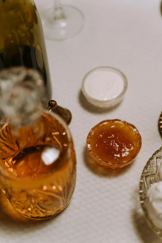 a bottle of wine sitting on top of a table, a still life, wearing honey, sugar, up close, moroccan