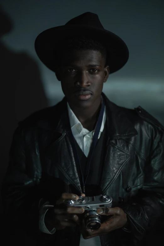 a man in a hat holding a camera, inspired by Gordon Parks, afrofuturism, adut akech, moonlight, professionally color graded, officer