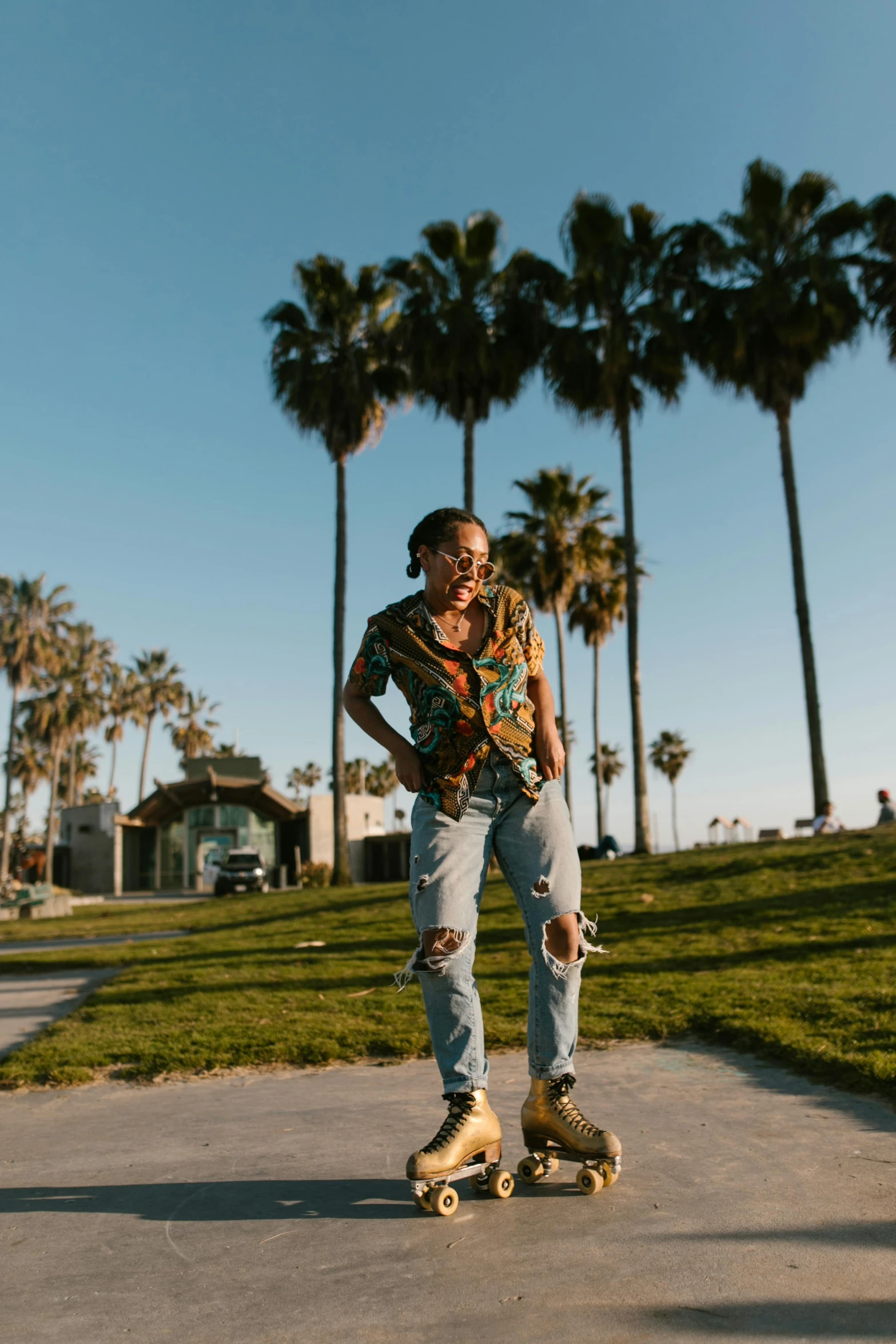 a man riding a skateboard down a sidewalk, by Winona Nelson, unsplash contest winner, palm trees on the beach, portrait willow smith, woman posing, standing in grassy field