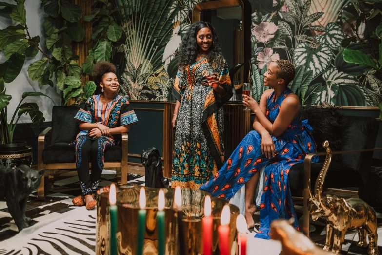 a group of women sitting around a table, by Julia Pishtar, pexels contest winner, black arts movement, wearing an african dress, in a room full of candles, celebration of coffee products, vintage vibe