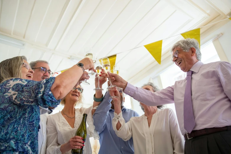 a group of people toasting with wine glasses, a portrait, pexels contest winner, private press, yellow awning, 70 years old, confetti, amanda lilleston