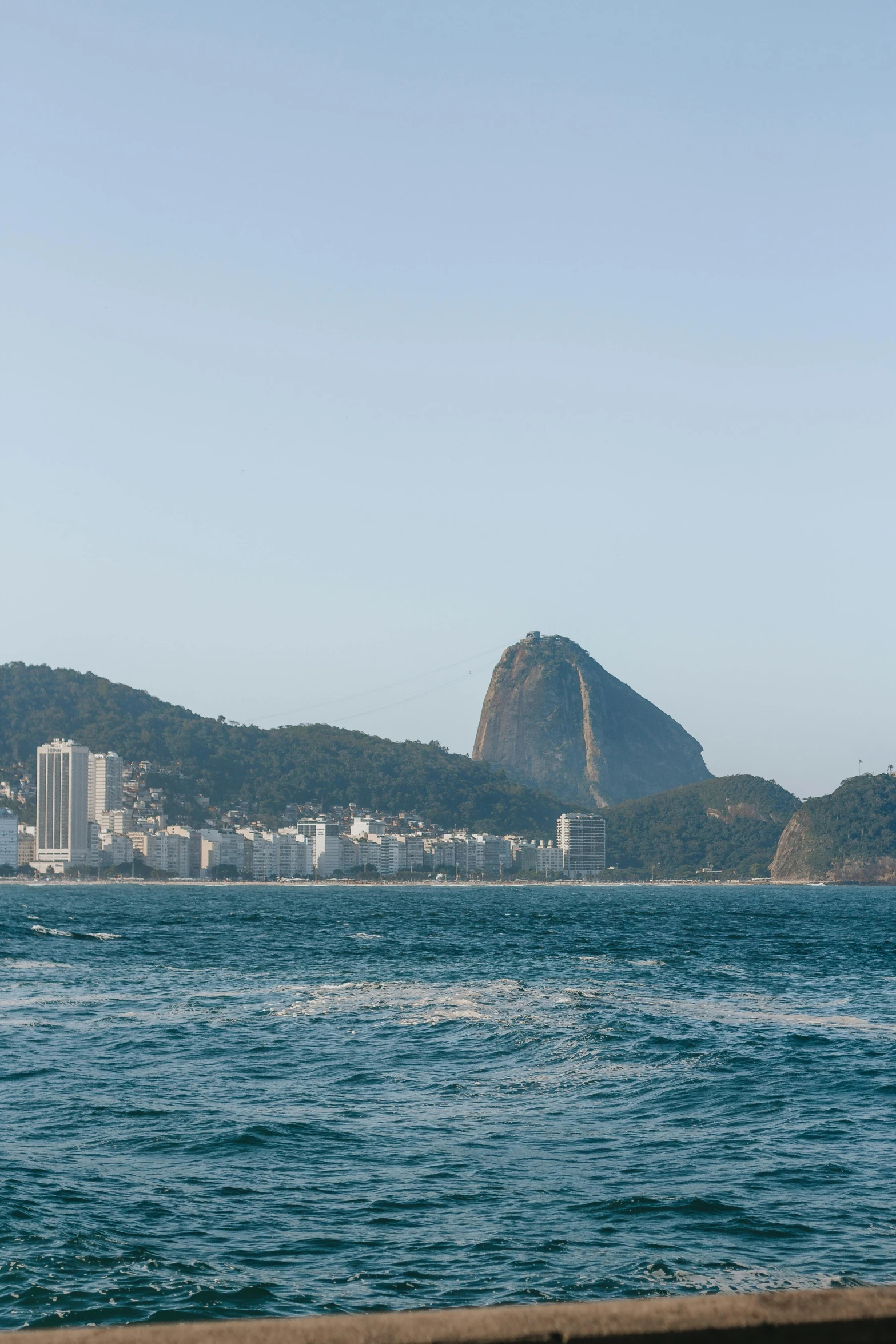 a large body of water with a mountain in the background, by Elsa Bleda, cristo redentor, city views, oscar niemeyer, on the coast