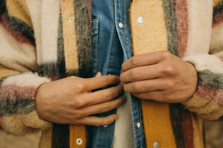 a close up of a person wearing a jacket, by Carey Morris, muted arm colors, denim, autumnal, hands straight down